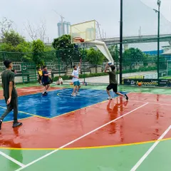 A player takes a jump shot on a wet court, showing focus and determination.