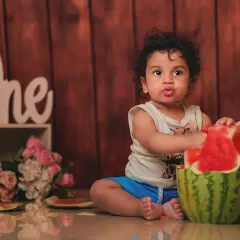 Getting hands-on with a juicy watermelon. This fruit smash session is a unique and colorful way to capture your baby's milestone moment.