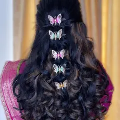 I love when clients want to have fun with their look. This modern, romantic hairstyle features soft curls and whimsical butterfly clips, perfect for an engagement party or reception.