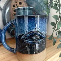 This striking evil eye mug was created in one of my hand-built mug workshops. The glossy blue glaze makes the design pop.