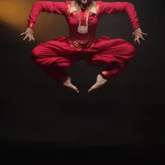 Capturing the peak of energy and expression in a single, frozen moment. This shot from a Bharatnatyam dance session shows the power and discipline of the art form, achieved with precise studio lighting against a dark backdrop.