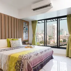 This home isn't just designed, it's curated. A perfect play of colors, with a cozy bedroom featuring a plush headboard and a stunning city view.