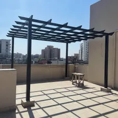 This is the foundational stage of a rafter pergola. The image shows the bare metal structure installed on a rooftop, ready for the next steps of adding flooring, planters, furniture, and lighting.