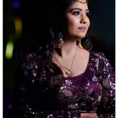 A stunning portrait of a woman in an ornate purple lehenga at her engagement event, showcasing our skill in lighting and capturing detail.