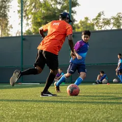 One-on-one guidance is key to development. Here, a coach works closely with a player, demonstrating a technique during a practice session designed to improve ball control and dribbling skills.