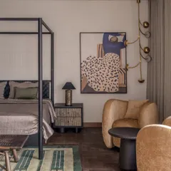 Another angle of the parent's bedroom, showing the cozy seating area. The plush, curved armchair adds a soft, sculptural element to the room, making it a perfect spot for reading.