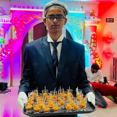 A server presenting a tray of starters in individual portions. This passed service is perfect for parties where guests are mingling, like this 5th birthday celebration.