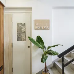 The entrance to the 'Nordic Nest' sets a tranquil tone. Clean lines, a simple wooden nameplate, and a touch of greenery create an atmosphere of understated Scandinavian elegance that awaits within.