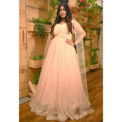 This peach gown with a sparkling overlay and attached cape sleeves is a glamorous option for any formal event, from a cocktail party to a wedding reception.