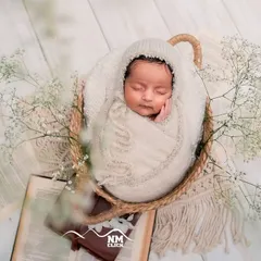 Another angle of this angelic newborn. We use soft, neutral tones and textures to keep the focus entirely on your baby's perfect little features.