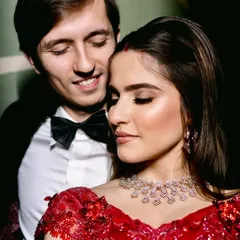 A close-up of a timeless reception look. The focus here is on flawless skin, soft yet defined eyes, and a classic red lehenga, creating a moment of pure elegance and modern romance for the new bride.