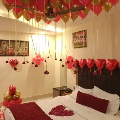 I can turn any hotel room into a romantic haven. This classic "I love you" decor uses a red and gold theme with dozens of helium balloons on the ceiling, rose petals on the bed and floor, and heart-shaped foil balloons to complete the look.