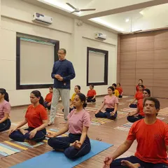 An instructor provides guidance during a group meditation session. Our classes maintain a focus on individual awareness even in a group setting, ensuring each practitioner receives the attention needed for correct and safe practice.