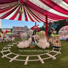 A spectacular circus-themed party setup featuring our kids' white train ride on a track, surrounded by hot air balloon decorations and a festive tent.