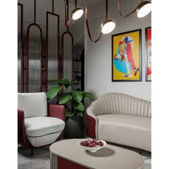The waiting lounge is designed to be a statement in itself, with custom-designed scalloped and two-toned sofas. The vibrant pop-art and unique leather-strap lighting add a playful, urban edge to the sophisticated Art Deco-inspired furniture.