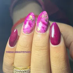 A vibrant pink and magenta set featuring a marble effect on two nails, accented with delicate gold foil.