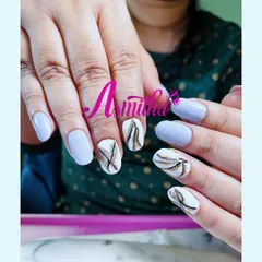 A fresh and artistic nail set combining a matte periwinkle blue with white accent nails. The accent nails feature a delicate, abstract marble design in black and gold.