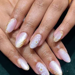Delicate and dreamy. These almond-shaped nails feature a pearly base with hand-painted white daisies and a touch of gold, perfect for a soft, feminine look.