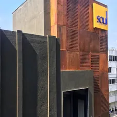 A detail shot of the Koramangala commercial property, highlighting the contrast between the textured dark grey finish and the weathered steel panels.