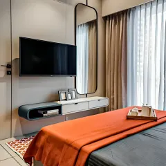 This modern bedroom features a floating console that serves as both a TV stand and a compact dressing table, saving space while maintaining a clean, uncluttered look.