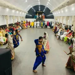 A Garba performance for a pre-wedding event. The guests are seated in a circle, creating an intimate and interactive setting for the dancers.