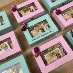 A full display of our bridesmaid proposal boxes in alternating pink and mint green. Each box features a window to peek at the gifts inside and is topped with a delicate floral accent.