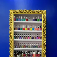 I believe in using high-quality products. This ornate, gold-framed shelf displays just a fraction of the vast range of nail polish colors and finishes I have available for you to choose from.