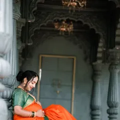 A serene moment captured as the expectant mother sits peacefully, framed by majestic pillars. This shot emphasizes the quiet joy and anticipation of motherhood.