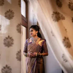 This bride looks thoughtful and beautiful by the window. Her reception makeup is soft and romantic, designed to catch the light and give her a gentle glow.