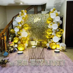 A straight-on view of the gold and white party setup, with personalized marquee letters in the foreground.