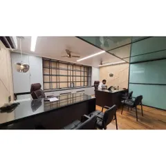 A full view of the executive office cabin designed for Mr. Vishesh. The layout includes a primary work desk and a separate meeting table, all within a cohesive design featuring a dark, glossy tabletop and premium leather chairs.