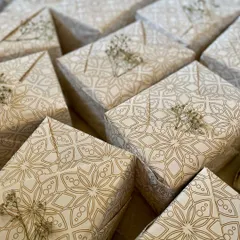 We believe presentation is part of the gift. Here’s a look at a bulk order of wedding favours, each one wrapped in elegant, recycled paper and finished with a sprig of dried baby's breath. It’s our way of ensuring your gifts are as beautiful on the outside as they are on the inside.