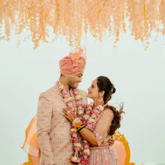 A sweet portrait of the couple under a hanging floral installation. The bride's embrace and their happy expressions make this a heartwarming and beautiful shot.