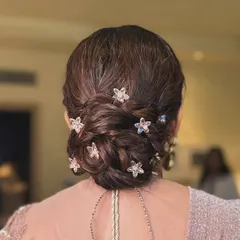 A detailed shot of the elegant braided bun I created for the mother of the bride, adorned with star-shaped accessories.