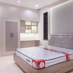 This is a wider view of the guest bedroom, showing how the wardrobe, loft storage, and study nook form one cohesive unit. The neutral palette and thoughtful lighting make the space feel welcoming and calm.