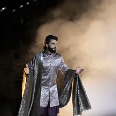 Ranveer Singh emerges from a cloud of smoke, creating a dramatic and powerful entrance on the runway. This shot is all about capturing the theatricality of a fashion show.