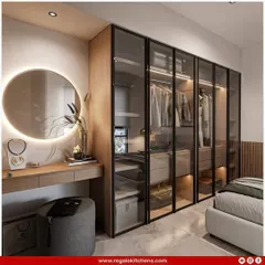 We integrated a full vanity table into this wardrobe design, complete with a lit circular mirror. The glass doors offer a peek at the organized interior, blending functionality and style.