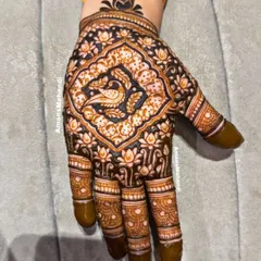 A rich and dense back-of-hand design with a central peacock motif. The beautiful dark stain highlights the intricate details of the lotus and vine patterns.