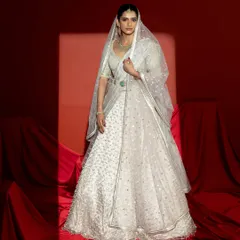 The complete bridal look, featuring the ivory lehenga with a sheer, embellished veil. This view showcases how the ensemble comes together to create a vision of grace and sophistication, perfect for the bride's grand entrance.
