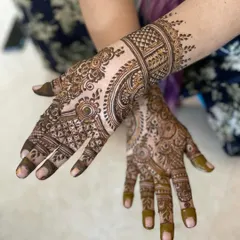 This design combines geometric grids with flowing, traditional patterns, extending from the fingers to the wrist. It's a beautiful example of a full-coverage party mehendi.
