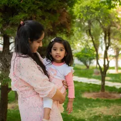 A mother holding her daughter in a beautiful park. My outdoor family sessions are relaxed, allowing for natural and loving portraits like this one.