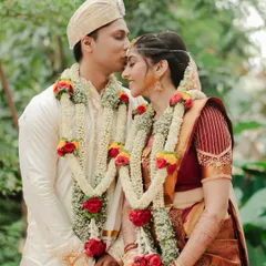 A gentle kiss on the forehead, a timeless gesture of love and protection. This tender moment between the couple, adorned in their beautiful South Indian wedding garlands, is a perfect example of the quiet intimacy we love to capture.