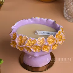 This lilac Jesmonite urli-style candle holder is adorned with golden flowers, blending modern material with traditional design.