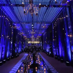 A study in blue. This royal blue-themed entrance featured dramatic draping, elegant chandeliers, and a mirrored walkway, reflecting the light to create an endless, enchanting path for guests.