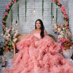 A serene seated portrait in the pink gown, surrounded by flowers.