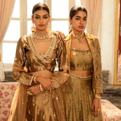 A dual-model shot showcasing two complementary outfits from a brand's collection. The composition highlights the relationship between the two ensembles, focusing on the rich textures and coordinated color palette.