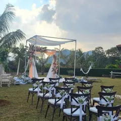 A side view of the elegant mandap setup. The focus is on the clean structure, delicate floral accents on the corners, and the pristine white platform, perfect for a serene wedding ceremony.