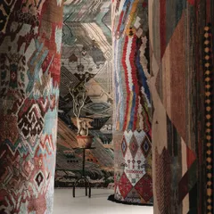 We believe walls are storytellers. This installation demonstrates how textiles can transform a space, using intricately designed rugs as vertical art to create an immersive corridor of pattern, texture, and color that envelops the viewer.