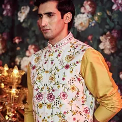 This Nehru jacket features a beautiful array of hand embellishments, including pearls and multi-color threadwork, for a festive baraati look.