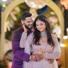 A sweet and romantic portrait from a reception, with the groom gently holding the bride's face as they share a smile.